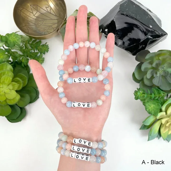 Armbånd Morganitt, hjertechakra. Elastisk armbånd 6 mm perler med tekste "Love".Morganitten hører til hjertechakraet og bærer energien fra guddommelig kjærlighet og medfølelse.